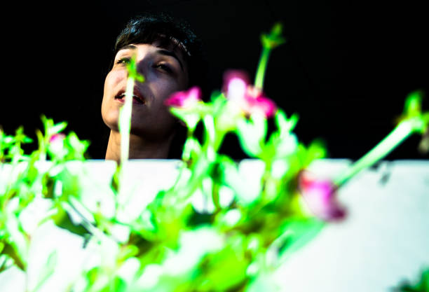 istock Young woman model posing leaning on the window with the sun lighting up his face. Wide angle lens, high contrast, selective focus. 824723596