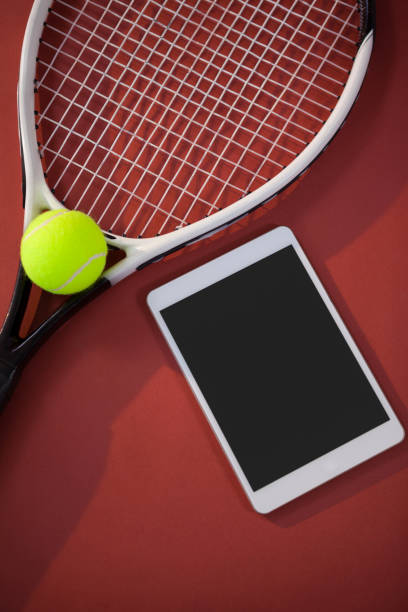 istock High angle view of tennis ball and racket by digital tablet 824723930