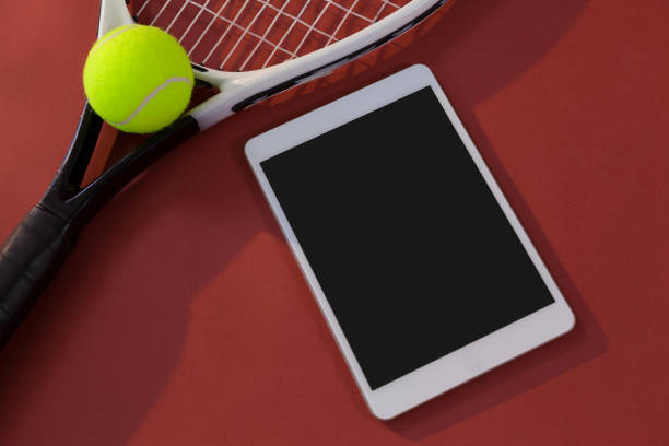 istock High angle view of tennis racket and ball by digital tablet 824723936