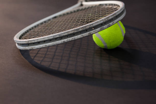 istock Close up of tennis racket on ball with shadow 824724054