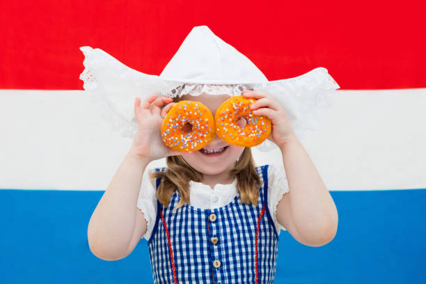 istock Dutch girl with orange donuts and Netherlands flag 824727056