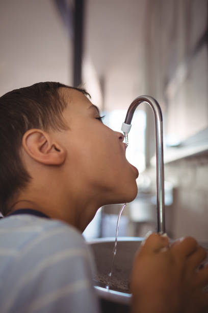 istock Close up of boy drinking water from faucet 824730320