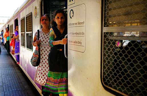 Mumbai, India - January 27, 2017: Women take a suburban train, the train has a special ladies car, the color of the car is pink.