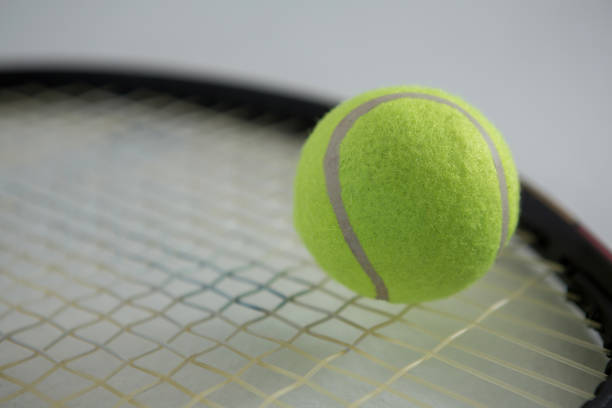 close-up de bola de tênis fluorescente na raquete - tennis racket ball isolated - fotografias e filmes do acervo