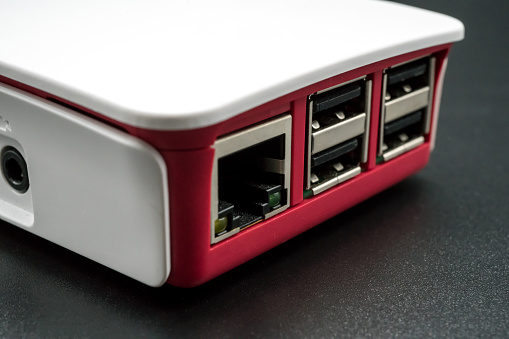 LAN and USB ports single-board computer in white and red plastic case isolated on black background