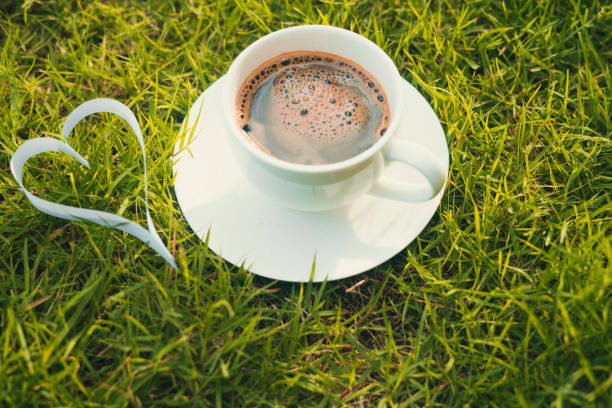 istock paper heart shape on grass and coffee 824740344