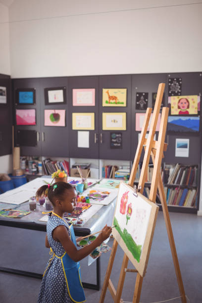 istock High angle side view of girl painting on canvas 824740558