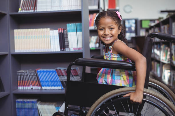 istock Smiling girl on wheelchair at library 824740960