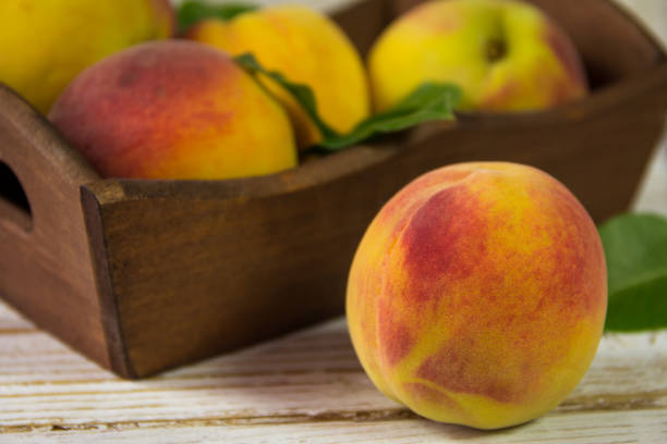 istock Fresh peach on a wooden background. Closeup 824743698