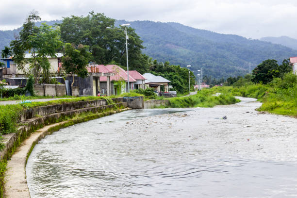 River on the edge of town with neatly lined houses, mountains and hills with fresh air