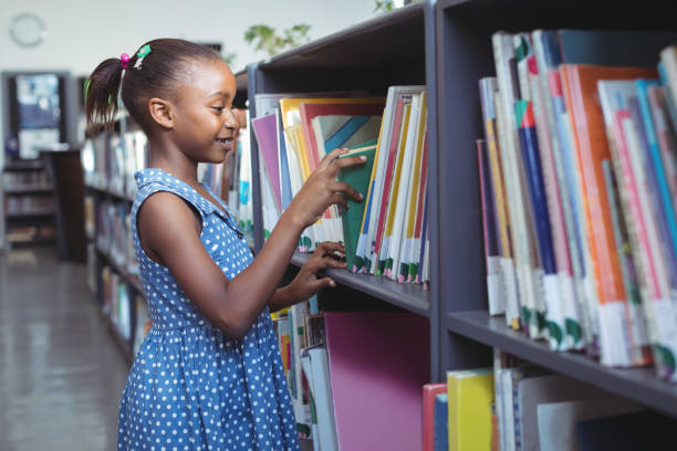 istock Girl choosing book in library 824750534