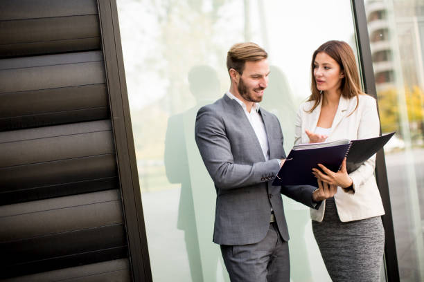 istock Young business people talking and viewing documents outdoor 824754036