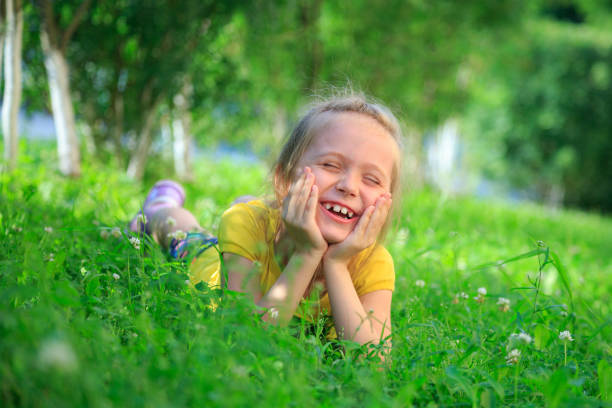 istock Little adorable girl lying on grass 824767360