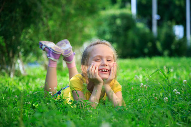 istock Little adorable girl lying on grass 824767406