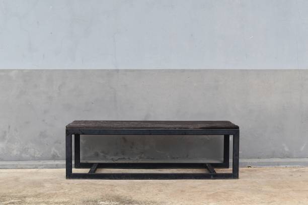istock steel long bench in front of dirty gray old wall 824777708