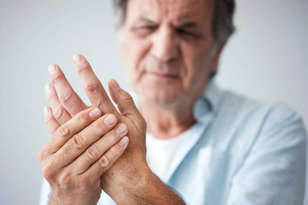 alter mann mit finger schmerzen - arthritis stock-fotos und bilder