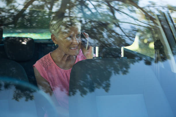 istock Senior woman talking on mobile phone in car 824785384