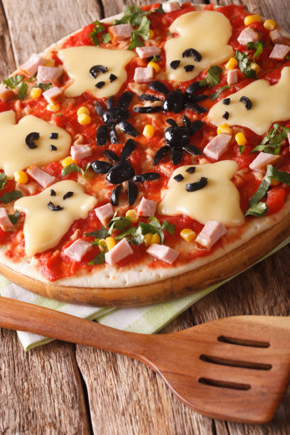 istock Halloween Food: Pizza with ghosts and spiders close-up. vertical 824787914