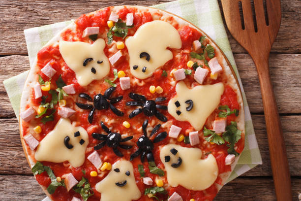 istock Pizza Halloween with ghosts cheese and olives spiders close-up. Horizontal top view 824789982