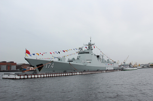 Military warship sailing in Neva River at St. Petersburg at sunset