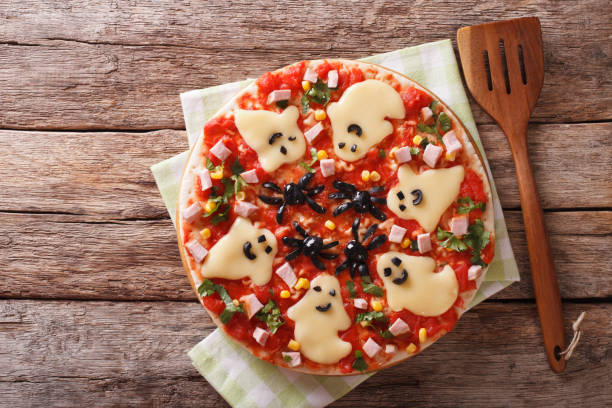istock Halloween Food: Pizza with ghosts and spiders close-up. horizontal top view 824792220
