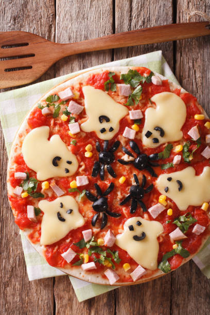 istock Pizza Halloween with ghosts cheese and olives spiders close-up. vertical top view 824792864