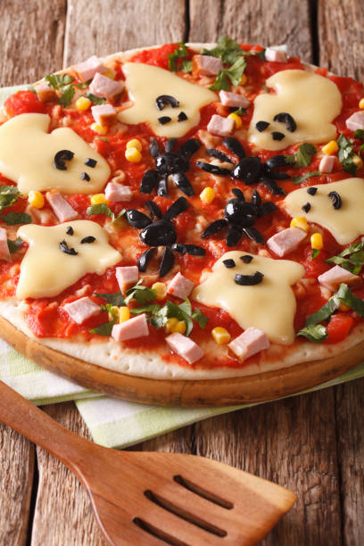 istock pizza for Halloween with ham, cheese and olives close-up. Vertical 824793880