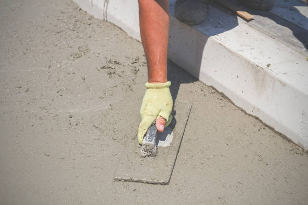 istock Construction worker leveling concrete pavement outdoors. 824794034
