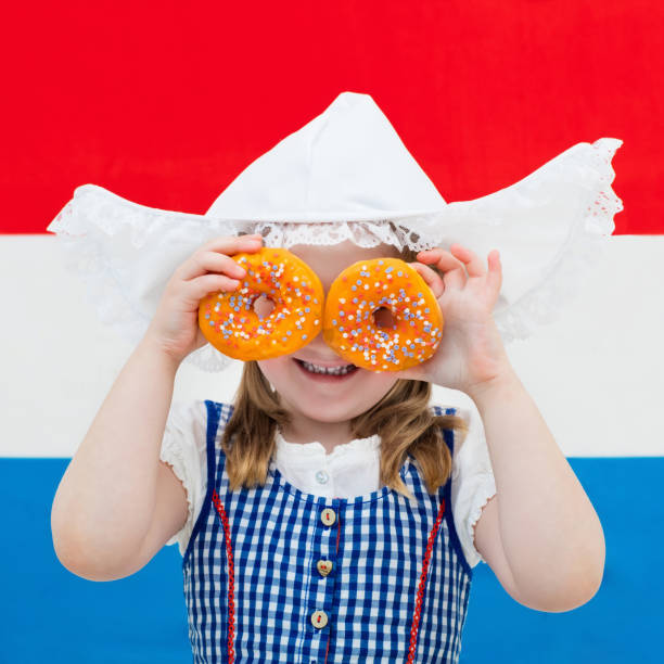 istock Dutch girl with orange donuts and Netherlands flag 824796854