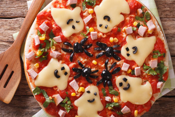 istock pizza for Halloween with ham, cheese and olives close-up. Horizontal top view 824797580