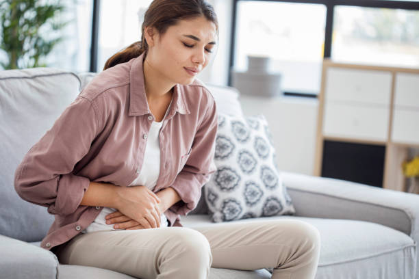 istock Young woman with stomach pain 824797776