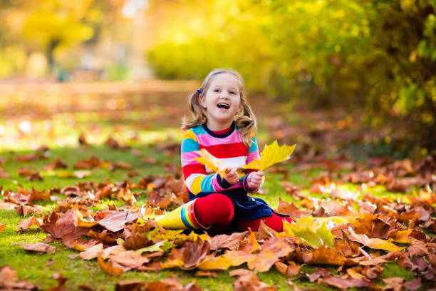 istock Child in fall park. Kid with autumn leaves. 824797872