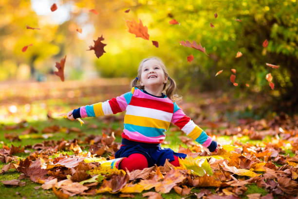 istock Child in fall park. Kid with autumn leaves. 824800718