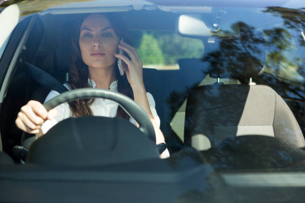 istock Woman talking on mobile phone while driving a car 824801124