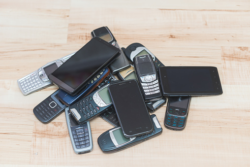 Pile of mobile phones. Old and new models