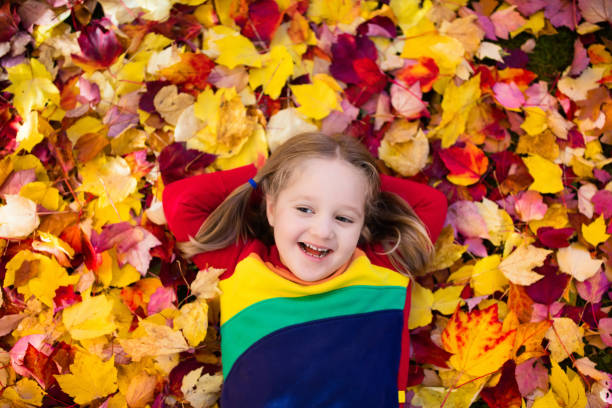 istock Child in fall park. Kid with autumn leaves. 824804176