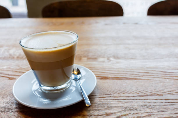 istock Coffee latte on a wooden table in a small mug 824810054