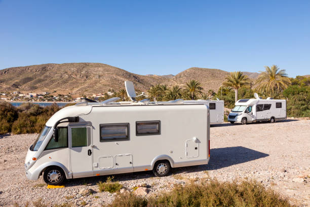 Motorhome at a campground Motorhomes parked at the mediterranean coast in southern Spain RV truck stock pictures, royalty-free photos & images