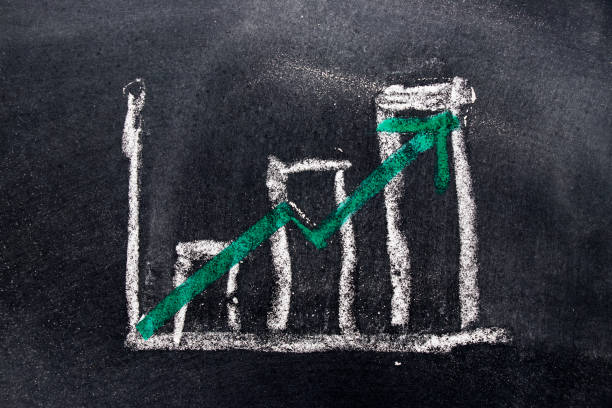 istock White chalk draw as bar chart and green chalk draw as upward arrow on black board background (Concept for sale, profit, cost of company in uptrend) 824812520