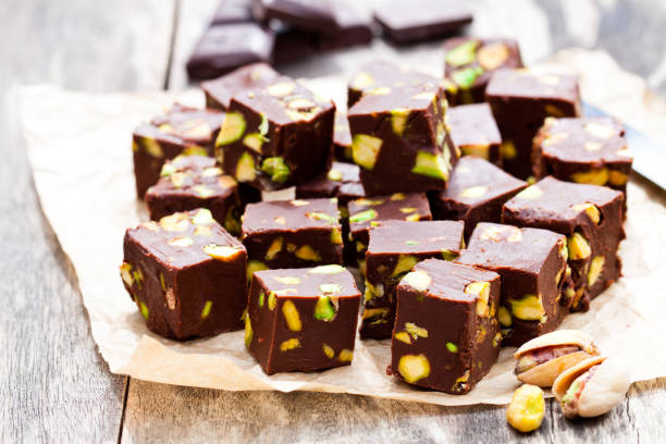 istock Dark  chocolate cubes with pistachios on wooden background 824812808