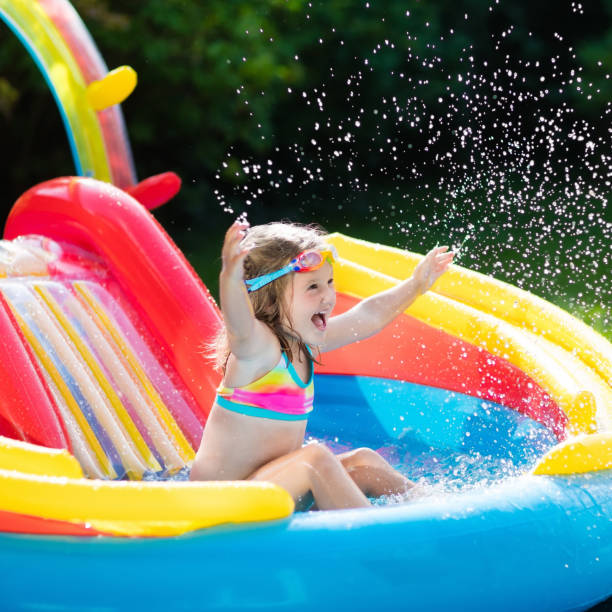 istock Child in garden swimming pool with slide 824815400