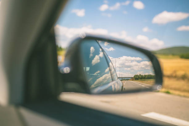 Traveling, rear view mirror road view and clouds