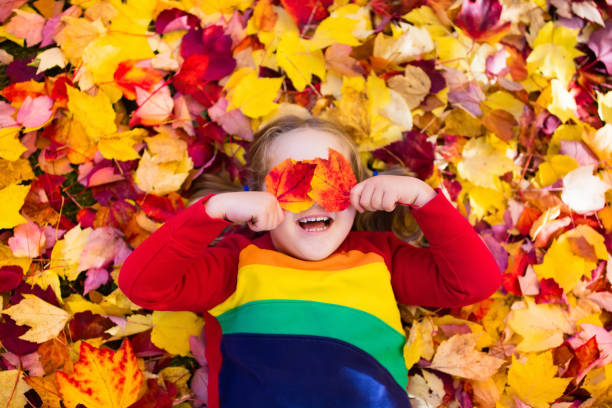istock Child in fall park. Kid with autumn leaves. 824816414