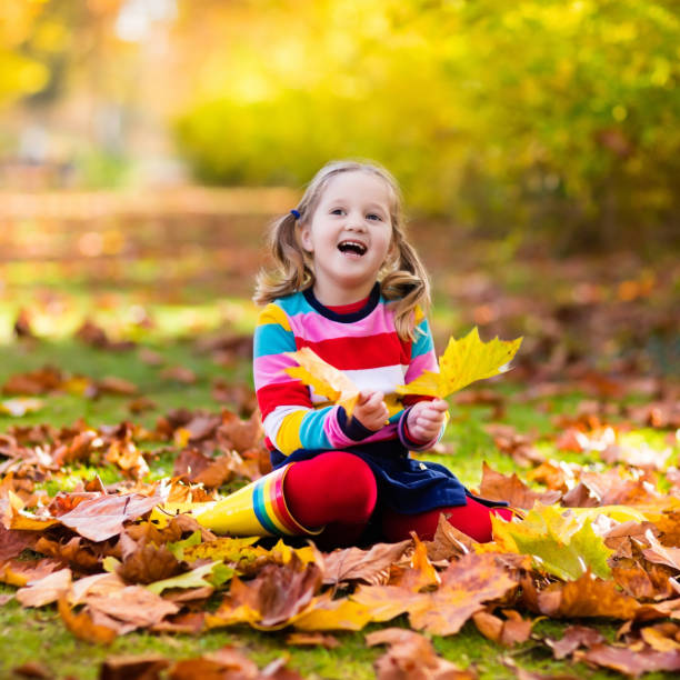 istock Child in fall park. Kid with autumn leaves. 824817204