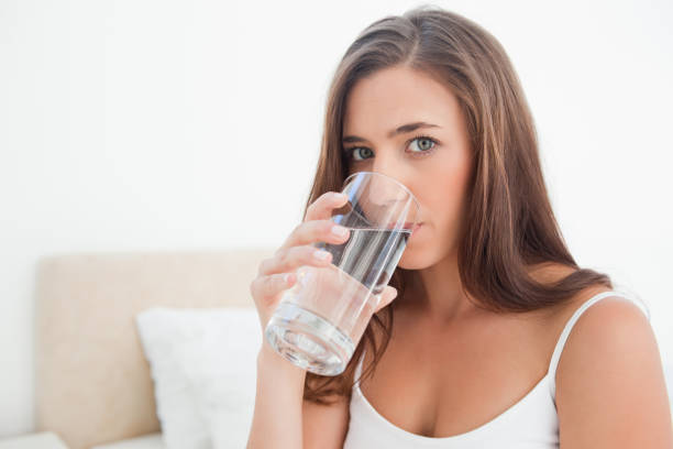 istock Woman looking forward drinking from a glass of water 824819652