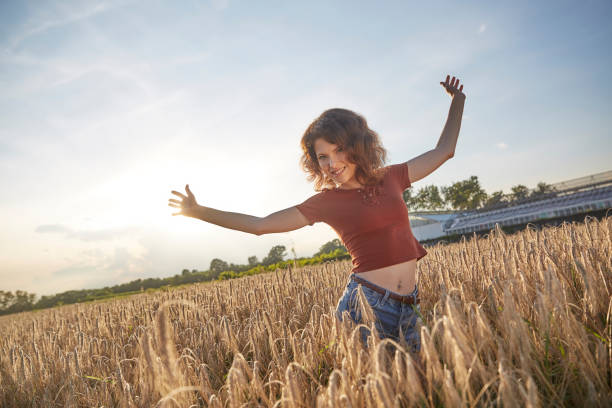 istock a beautiful woman standing on wheat field 824823728