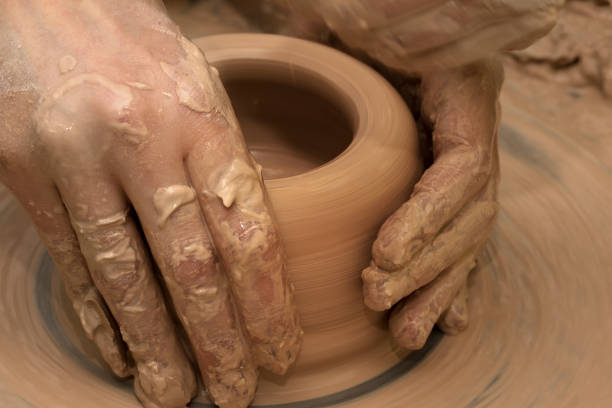 istock Women hands in process of making clay bowl on pottery wheel 824824098