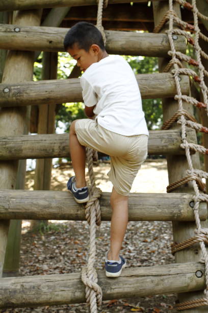 istock Japanese boy climbing on the wall (second grade at elementary school) 824827544