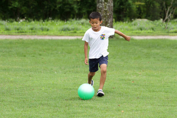 istock Japanese boy playing with soccer ball (second grade at elementary school) 824827546