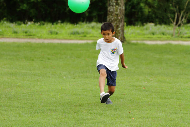 istock Japanese boy playing with soccer ball (second grade at elementary school) 824827560